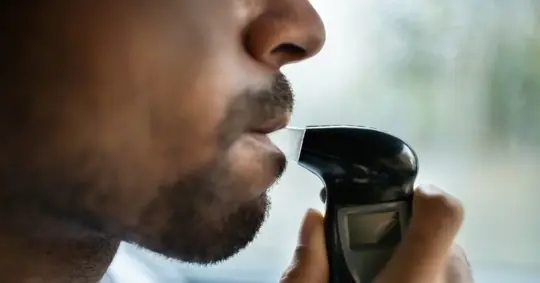 driver taking a breathalyzer test